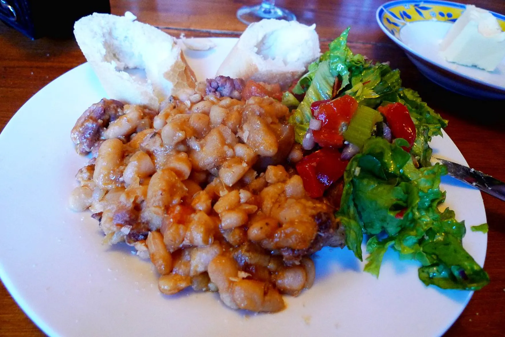 A plate of cassoulet with salad on the side.