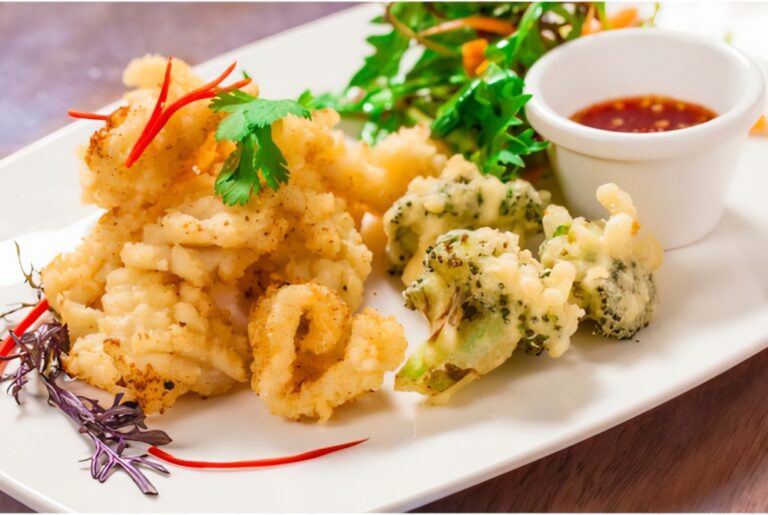 Chinese calamari ready to serve with broccoli tempura and a little pot of chili sauce.