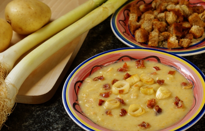 Potato leek soup with bacon topped with leek slices and bacon pieces.