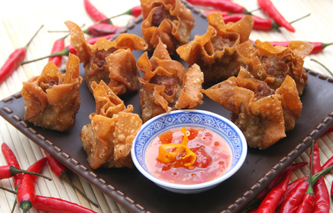 Overhead shot of crispy shrimp wontons with a dish of dipping sauce.