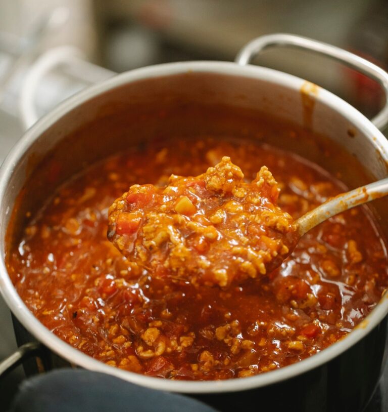 A large pot of chilil cooking on the stove.