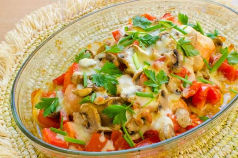 Baked chicken breasts with tomatoes and herbs in a baking dish.