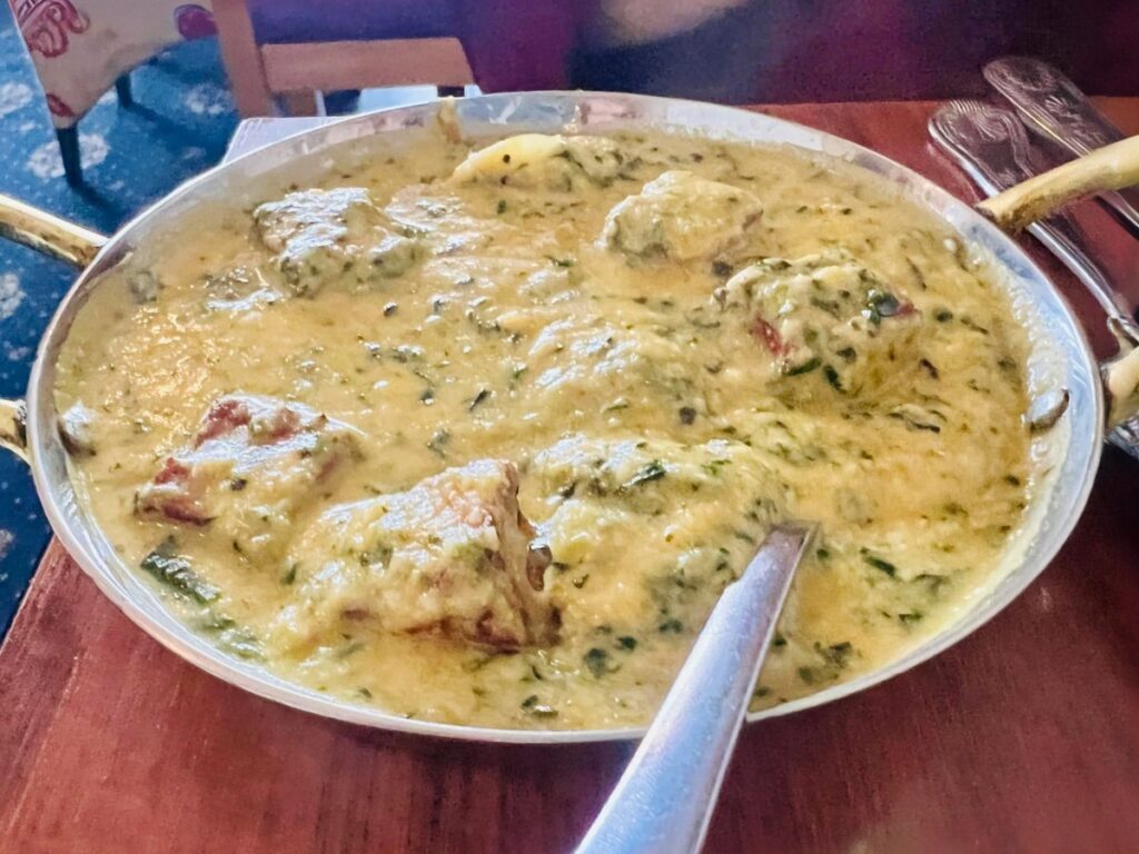 Creamy chicken pasanda in a serving bowl with a spoon.