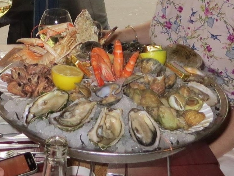 A large platter of oysters, prawns, clams, crab and sea snails at a restaurant in Paris.
