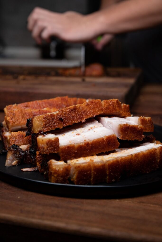 POrk belly slices and a person in the background.