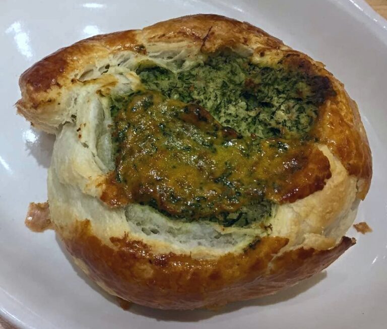 A potato and spinach knish on a plate.