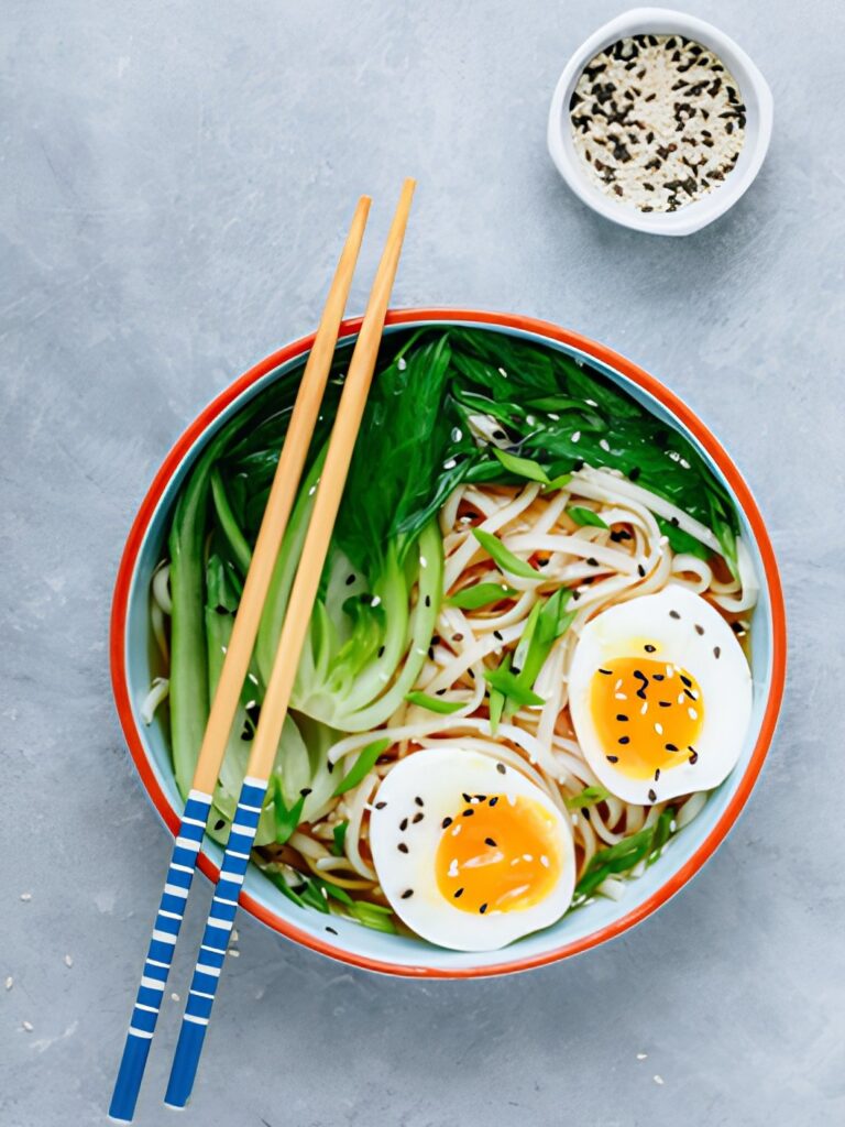 A bowl of bok choy soup with boiled eggs and noodles.