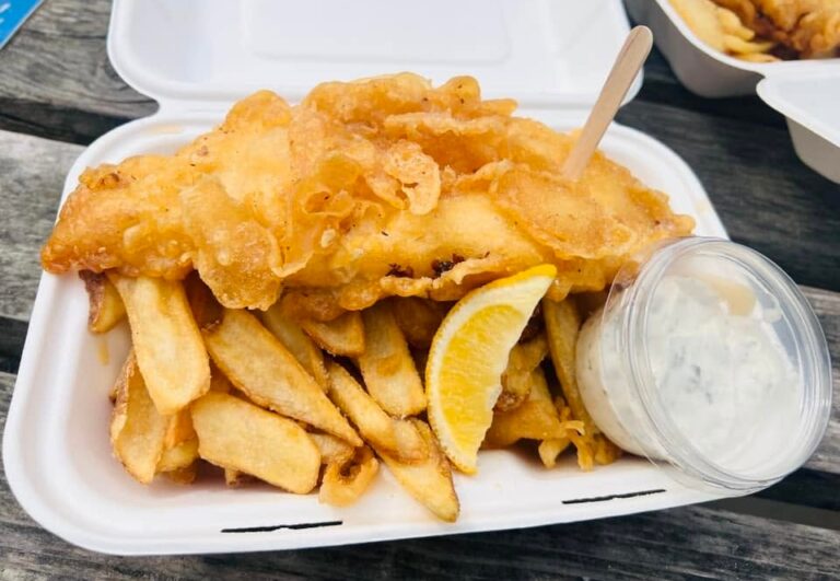 Closeup shot of battered fish, chips and tartar sauce, taken in Newquay, England.
