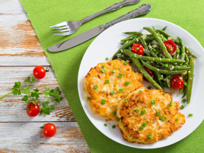chicken fritters on a plate with green beans and tomatoes