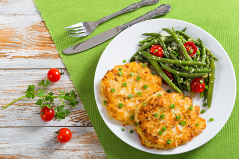 chicken fritters on a plate with green beans and tomatoes