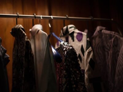 Clothes hanging on a rack in a dimly lit closet