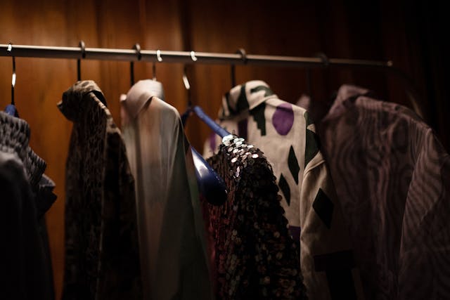 Clothes hanging on a rack in a dimly lit closet