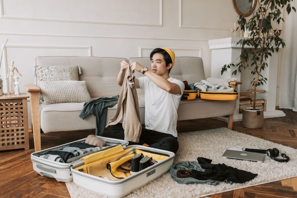 A person packing a suitcase on the floor and following expert tips to navigate the world confidently.