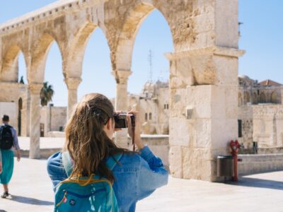 A woman photographing ruins at a historic site.