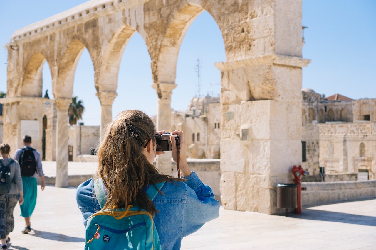 A woman photographing ruins at a historic site.