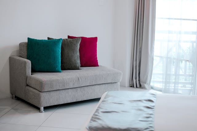 Grey sofa with three colorful cushions