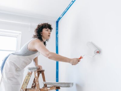 woman painting walls managing home maintenance solo