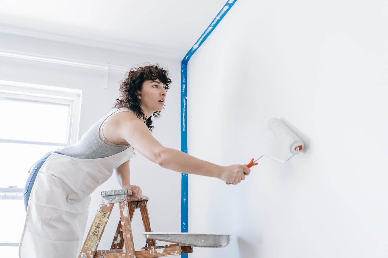 woman painting walls managing home maintenance solo