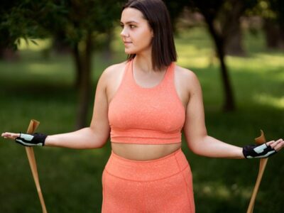 A woman working out outdoors with a stretch band