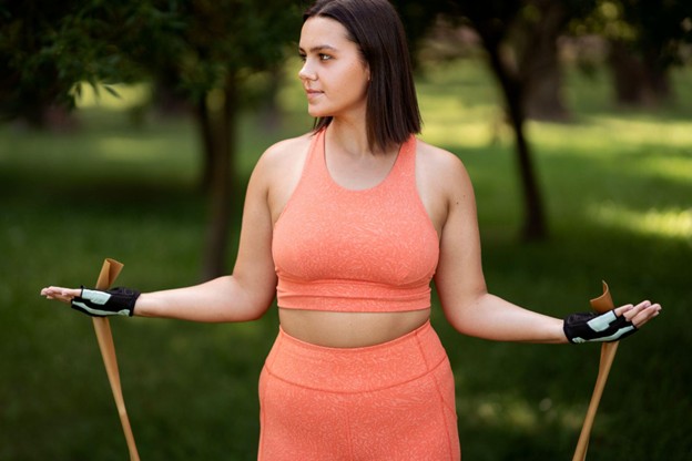 A woman working out outdoors with a stretch band