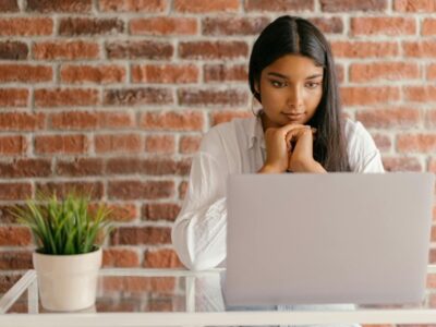 A girl sitting at a desk looking at a monitor