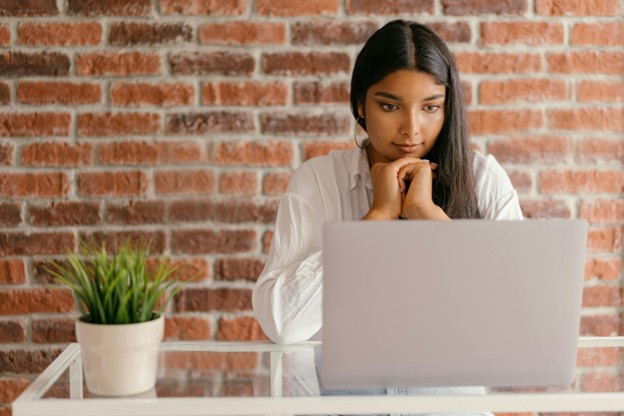 A girl sitting at a desk looking at a monitor