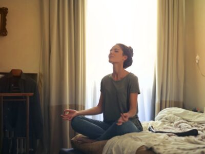 Woman meditating in her bedroom
