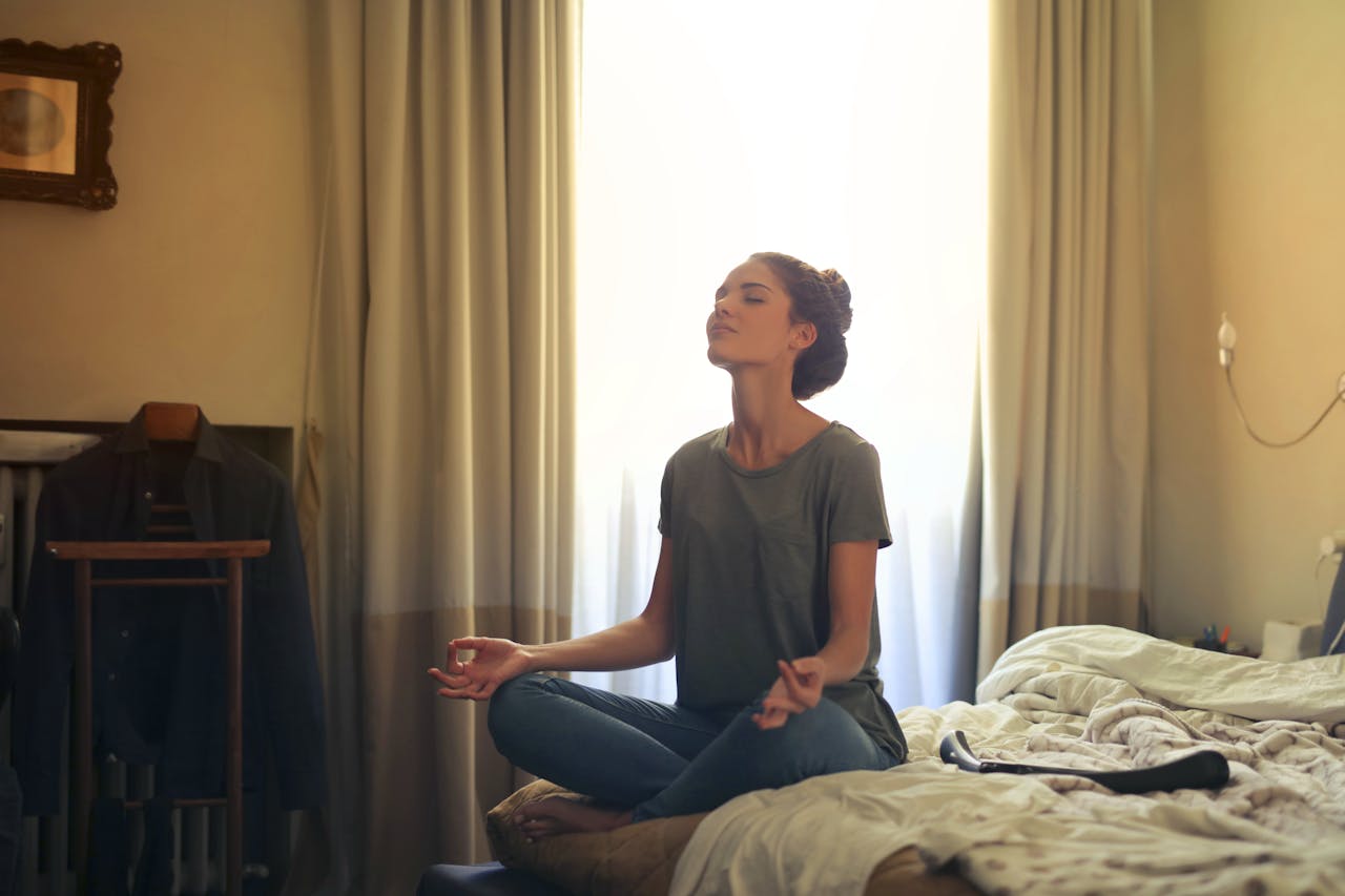 Woman meditating in her bedroom