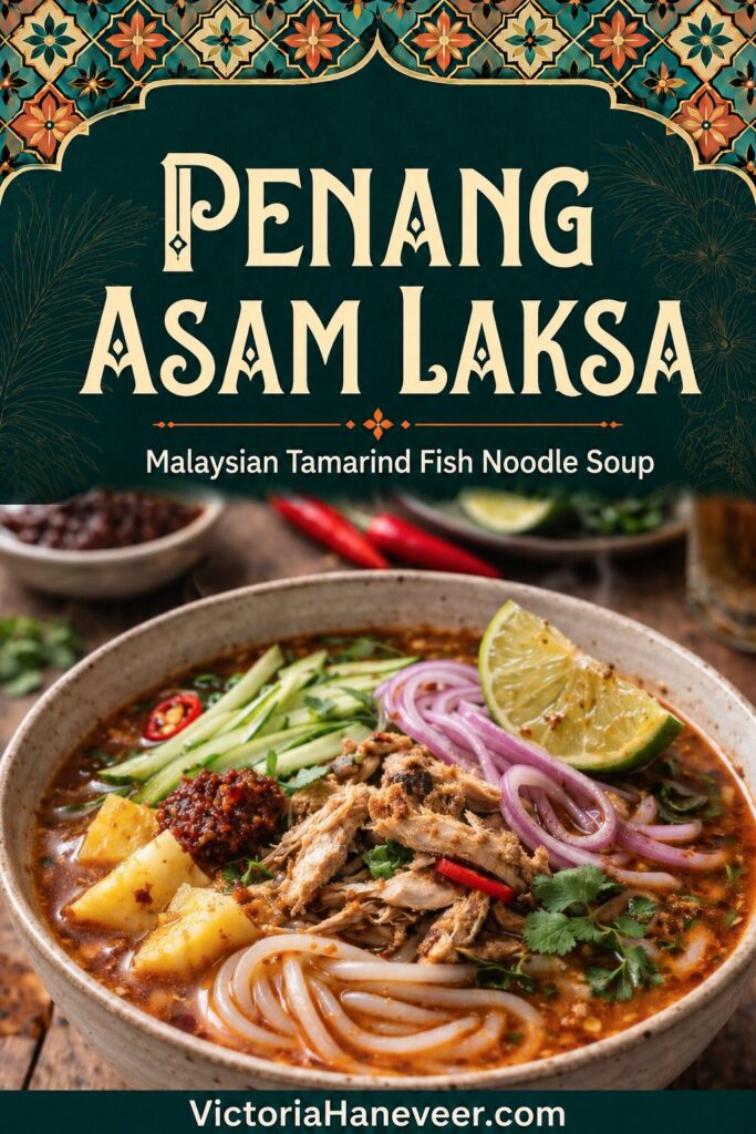 Penang asam laksa with flaked fish, rice noodles and fresh garnishes.