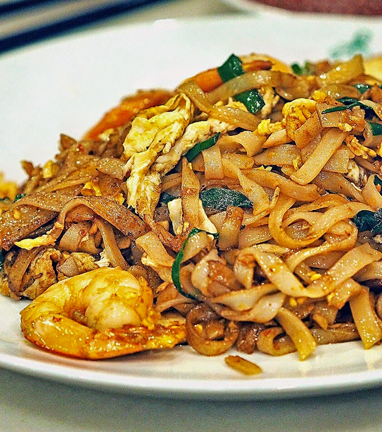 A close up of char kway teow with a prawn on the plate.