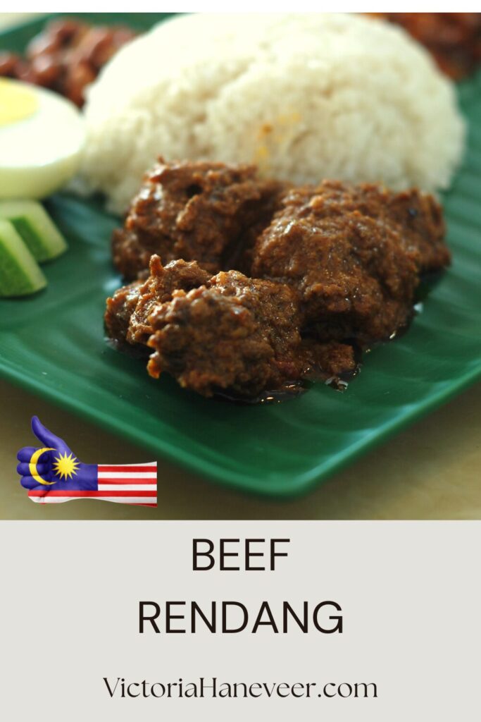 Traditional Malaysian beef rendang served with steamed rice and cucumber slices.