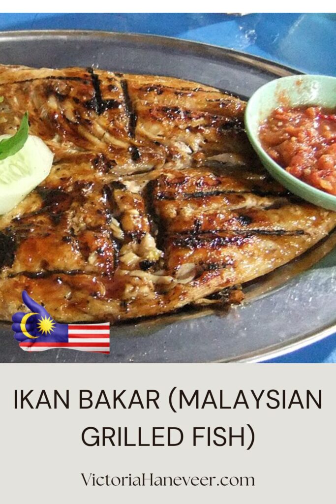 Malaysian grilled fish, ikan bakar, on a serving plate with sambal and cucumber garnish.