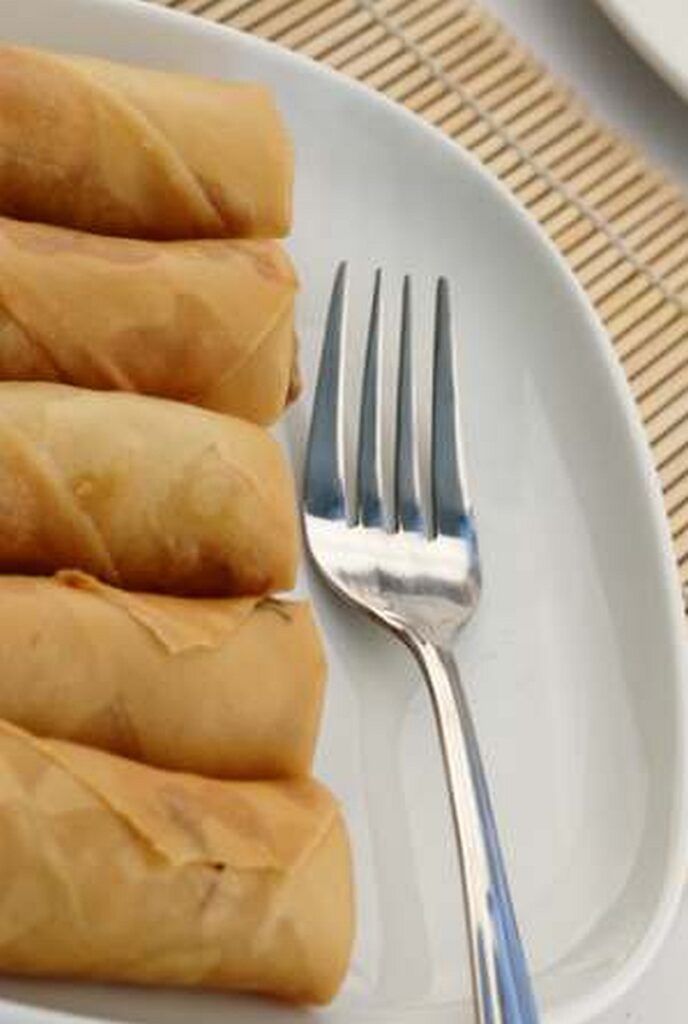 Popiah on a serving plate with a fork.