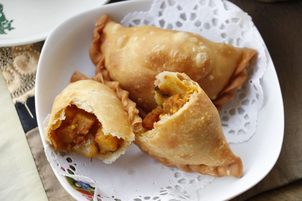 Kari puffs on a plate, one cut in half and the other left whole.