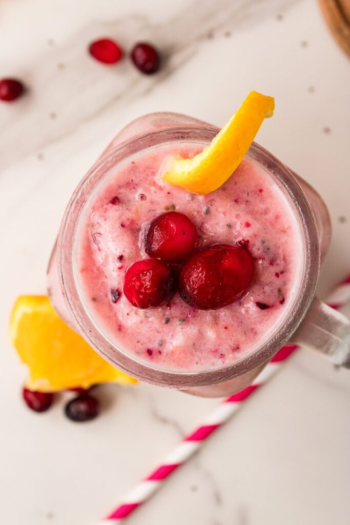 overhead cranberry smoothie with cranberry and orange garnish